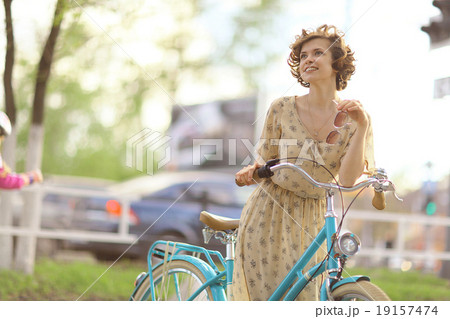 girl in a dress on a bicycle girl in a dress on a bicycle 19157474