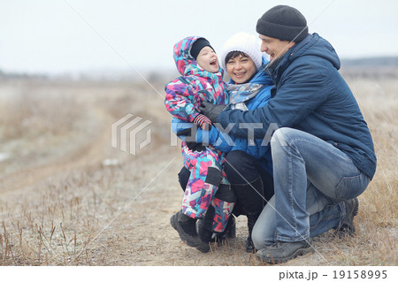 young family with a child playing on winter field young family with a child playing on winter field 19158995