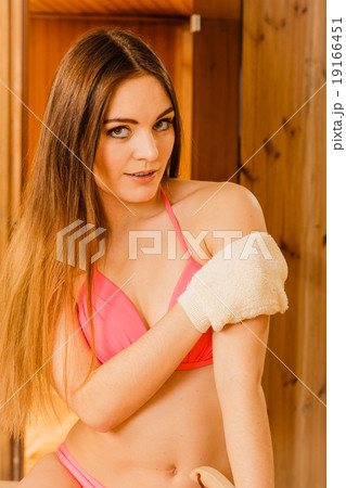 Woman in sauna with exfoliating glove. Skincare. Woman in sauna with exfoliating glove. Skincare. 19166451