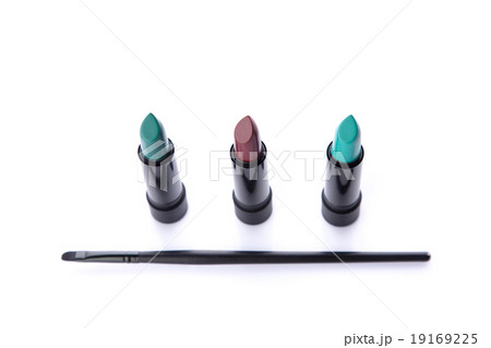 Top view of makeup brush and three lipsticks 19169225