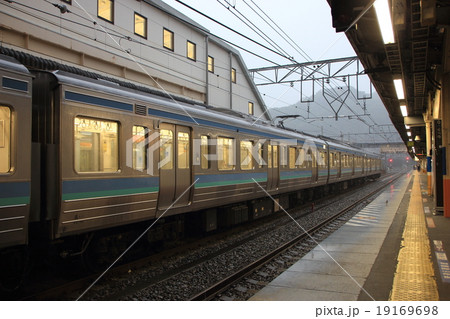 大雨の高尾駅に停車中の中央本線 19169698