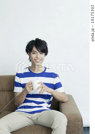 マグカップを持つ２０代男性の写真素材