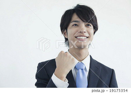 ガッツポーズをするスーツ姿の２０代男性の写真素材