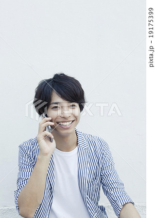 携帯電話で話す20代男性 携帯電話で話す20代男性 19175399