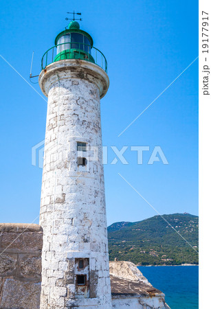 White stone lighthouse tower with green top White stone lighthouse tower with green top 19177917