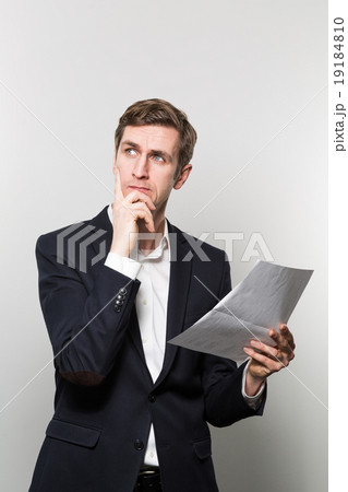 studio shot of businessman with sheet of paper studio shot of businessman with sheet of paper 19184810