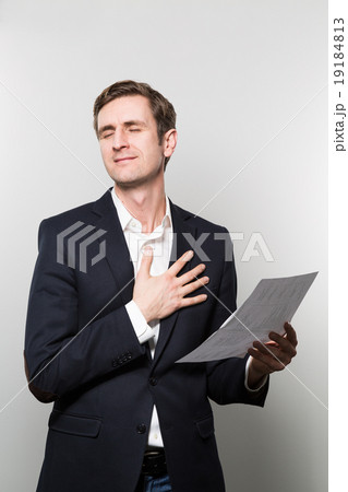 studio shot of businessman with sheet of paper studio shot of businessman with sheet of paper 19184813