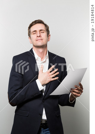 studio shot of businessman with sheet of paper studio shot of businessman with sheet of paper 19184814
