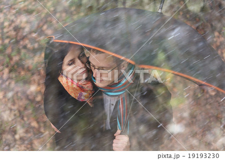 Lovers man and woman under an umbrella in the autumn forest 19193230