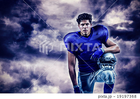 Composite image of portrait of serious sportsman holding helmet 19197368