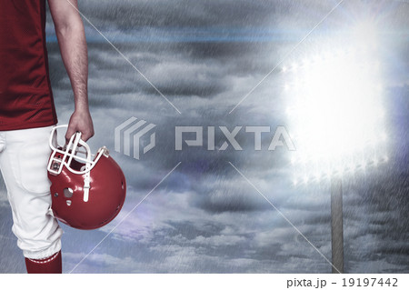 Composite image of american football player holding an helmet Composite image of american football player holding an helmet 19197442