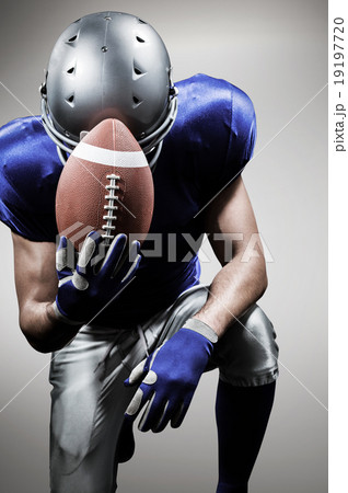 Composite image of upset american football player kneeling while Composite image of upset american football player kneeling while 19197720