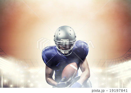 Composite image of american football player holding ball while k Composite image of american football player holding ball while k 19197841