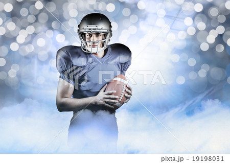 Composite image of confident american football player holding ba 19198031