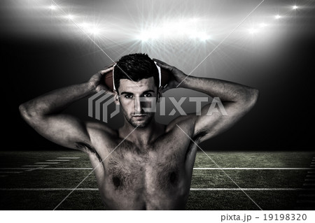 Composite image of portrait of a shirtless man holding ball over 19198320