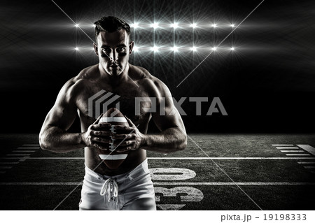 Composite image of shirtless american football player with ball 19198333