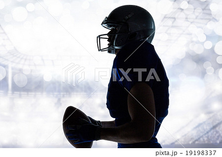 Composite image of side view of sportsman holding football 19198337
