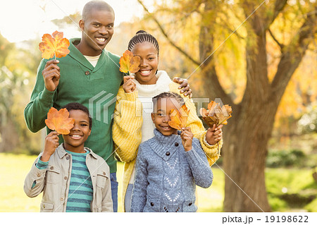 Portrait of a young smiling family holding leaves 19198622