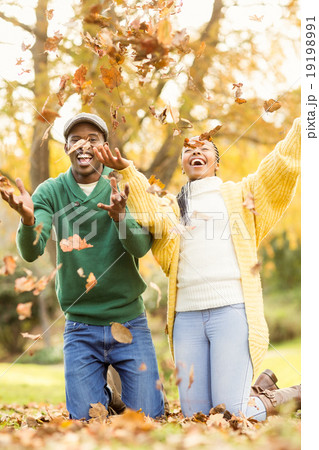 Portrait of a young couple throwing leaves around Portrait of a young couple throwing leaves around 19198991