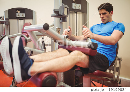 Fit man using weights machine for legs 19199024