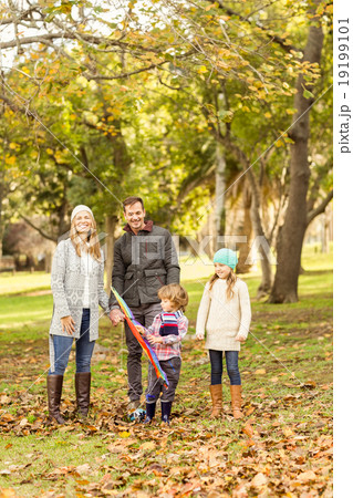 Young family playing with a kite 19199101