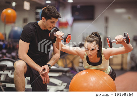 Fit woman working out with trainer 19199264