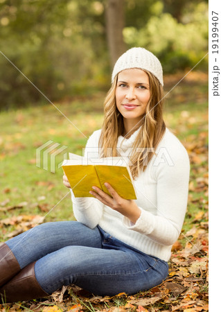 Portrait of a smiling pretty woman reading a book 19199407