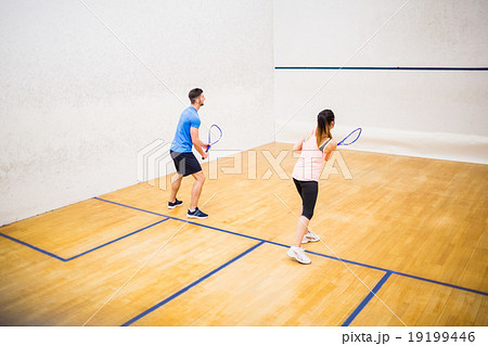 Couple playing a game of squash Couple playing a game of squash 19199446