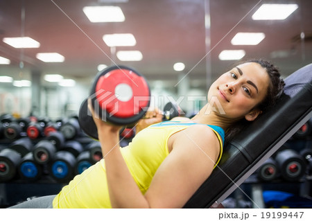 Smiling woman doing a workout with dumbbells Smiling woman doing a workout with dumbbells 19199447