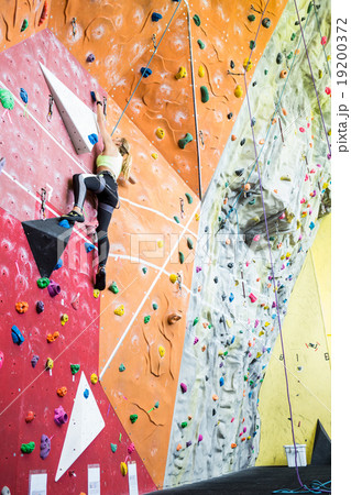 Fit blonde rock climbing indoors 19200372