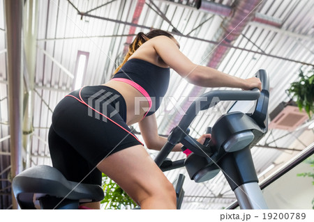 Woman using an exercise bike Woman using an exercise bike 19200789