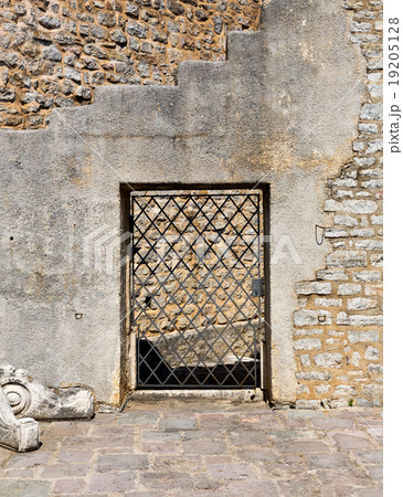 Arched old door in a stone wall 19205128