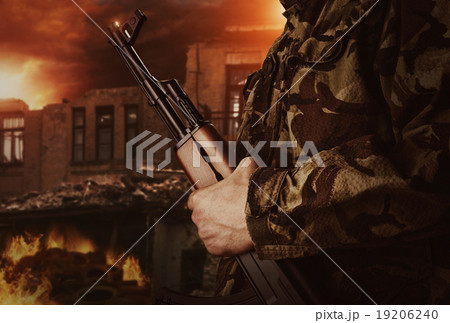 Soldier is holding gun on apocalyptic background 19206240