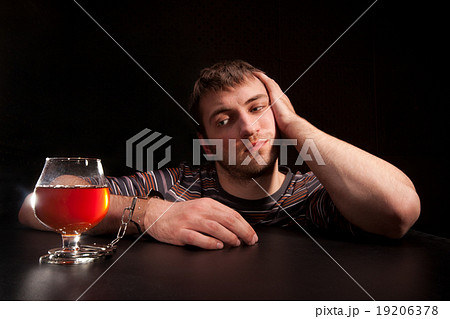Man locked to glass of alcohol Man locked to glass of alcohol 19206378