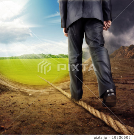 Businessman walking on tightrope 19206603
