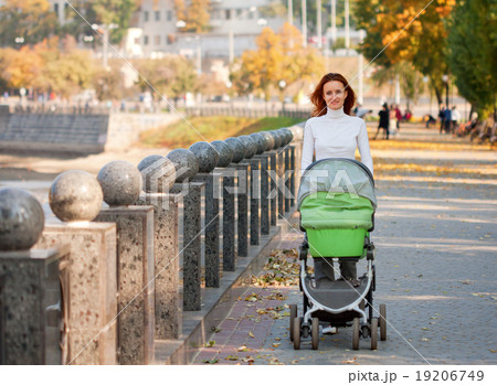Happy young mother with baby in buggy Happy young mother with baby in buggy 19206749