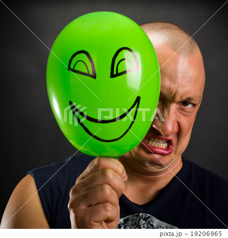 Angry man hiding behind happy balloon Angry man hiding behind happy balloon 19206965