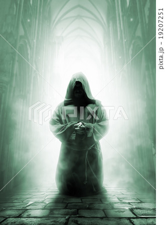 Praying medieval monk in dark temple corridor 19207251