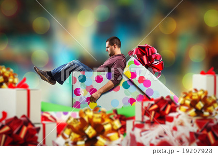 Adult man sits in present box 19207928