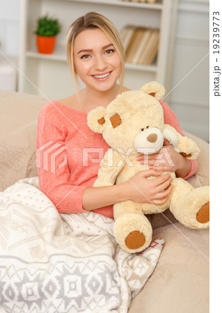 Young smiling woman posing with teddy bear. 19239773