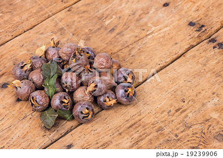 Healthy ripe Medlars on the old wooden table 19239906