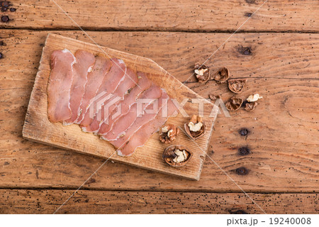 dried pork tenderloin on a rough rustic table 19240008