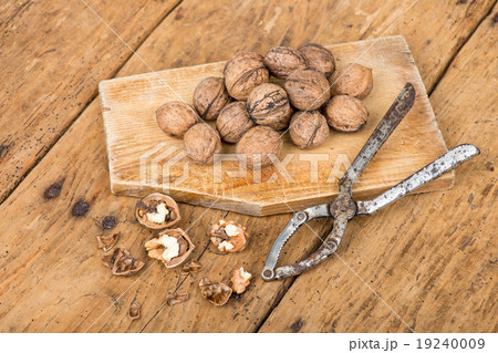 walnuts and nutcracker on an old rustic table 19240009