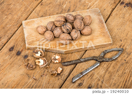 walnuts and nutcracker on an old rustic table 19240010