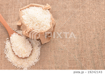 White paddy rice on wooden spoon and the hemp sack White paddy rice on wooden spoon and the hemp sack 19242143