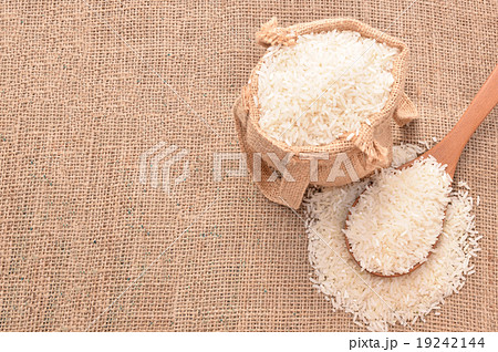 White paddy rice on wooden spoon and the hemp sack 19242144