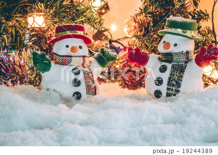 Snowman stand among pile of snow with a light bulb 19244389