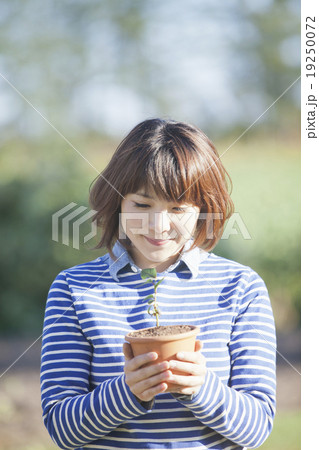 植木鉢を持つ女性の写真素材