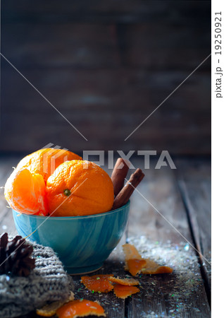 Tangerine in scarf over wooden background Tangerine in scarf over wooden background 19250921