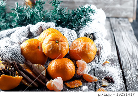 Tangerine in scarf over wooden background Tangerine in scarf over wooden background 19251417